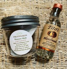 a glass jar filled with liquid next to a label on a woven tablecloth covered surface