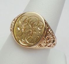 a gold signet ring with an image of a man's head on it