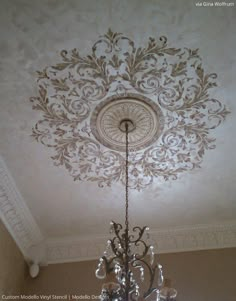 a chandelier hanging from the ceiling in front of a white painted wall with words stencil star on it