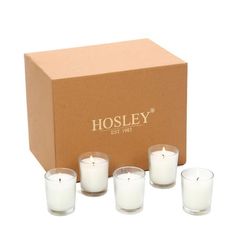 four candles in front of a box with the word hosley on it and six smaller ones