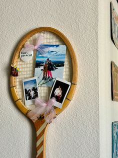 a tennis racket with pictures on it hanging from the wall next to other photos