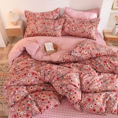 a bed covered in pink and white flowers on top of a checkered bedspread