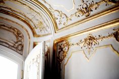 an ornately decorated room with gold trimmings and white paint on the walls