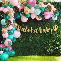 the balloon arch is decorated with tropical leaves and balloons for a baby's first birthday