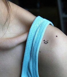 a woman's shoulder with a small tattoo on it