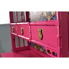 a pink dresser with drawers and handles on it