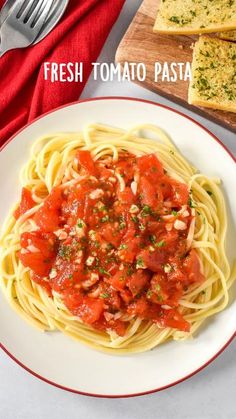 a plate of spaghetti with tomato sauce and garlic bread