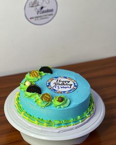 a blue and green birthday cake sitting on top of a table