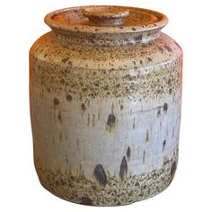 an old ceramic jar with brown spots on the outside and inside, is shown against a white background