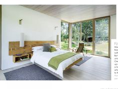 a bedroom with a large bed sitting next to a sliding glass door that leads out onto a lush green yard