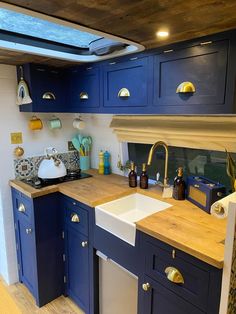 a kitchen with blue cabinets and wooden counter tops