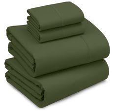 green sheets and pillow cases stacked on top of each other in front of a white background