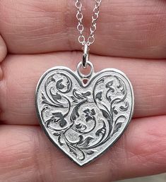 "Sterling silver heart is extremely detailed, made from a hand engraved model. It measures 29mm by 24mm ( without rings on top). Comes with 18\" sterling silver chain. 6.7g. Available in 14kt gold also. Money back guarantee within 14days. Buyer pays return shipping and must be returned in original condition with box and no alterations." Engraved Medallion Heart Necklace For Valentine's Day, Engraved Medallion Heart Necklace For Gift, Engraved Heart Medallion Necklace For Gift, Classic Heart-shaped Engraved Locket Necklace, Classic Engraved Heart Locket Necklace, Classic Engraved Heart Shaped Locket Necklace, Engraved Open Heart Locket Necklace, Sterling Silver Etched Pendant Locket Necklace, Silver Stamped Heart Pendant Jewelry