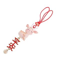 a pink pig is hanging from a red ribbon with the word yeah on it's side