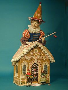 a figurine of a man on top of a gingerbread house with a broom