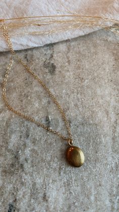 Mini brass locket on a gold fill chain. The daintiest oval shape, minimal + lovely. Can be stamped with one initial or birth flower on the inside, or filled with a picture. Dainty Pendant Locket Necklace, Dainty Gold Oval Pendant Locket Necklace, Dainty Gold Oval Locket Necklace, Dainty Oval Gold Necklace, Dainty Brass Locket Charm Necklace, Dainty Oval Pendant Locket Necklace With Adjustable Chain, Gold Oval Pendant Brass Charm Necklace, Gold Oval Charm Necklaces, Gold Oval Pendant Charm Necklace In Brass