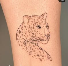 a tattoo on the leg of a woman with a cheetah head in black ink