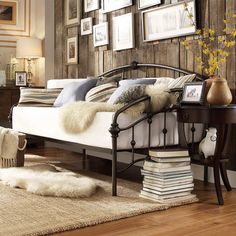 a bedroom with wood paneled walls and white bedding in the center, along with various framed pictures on the wall