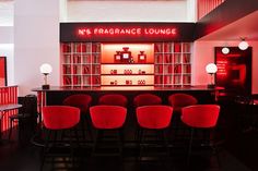 a bar with red chairs in front of it and a neon sign that reads n'sfragance lounge