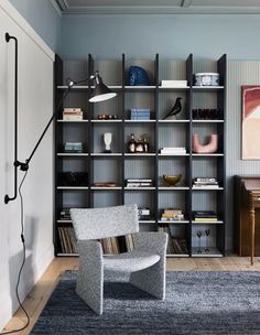 a living room filled with furniture and bookshelves next to a painting on the wall