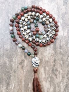 A mala is a Buddhist prayer rosary consisting of 108 beads + 109 Guru Bead. Each bead is threaded on a silk cord and separated by a knot tied during meditation and chanting (mantra recitation).  This handcrafted mala by me is made of Jasper, Dalmatian Jasper, and Indian Agate stones.  The mala is completed with a Guru Bead in the form of Dalmatian Jasper. The bead diameter is 6mm. Spiritual Agate Mala With 108 Beads, Adjustable Agate Hand-strung Mala, Adjustable Hand-strung Agate Mala, Bohemian Agate Mala With Gemstone Beads, Bohemian Mala With Natural Agate Stones, Bohemian Agate Mala For Meditation, Bohemian Agate Mala With Natural Stones, Bohemian Agate Mala For Healing, Agate Gemstone Beads Mala For Meditation