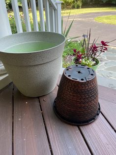 a planter sitting on top of a wooden deck next to a potted plant