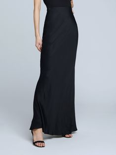 A stunning, understated maxi skirt in pure black. Bias-cut, silk-like fabric falls in a subtle, lustrous cling over the figure, enhancing and elongating the silhouette. Smooth elastic waist with no closures. Fitted Bias Cut Maxi Skirt For Night Out, Elegant Floor-length Satin Skirt, Sleek Full-length Bias-cut Maxi Dress, Silk Fitted Maxi Skirt For Gala, Satin Floor-length Evening Skirt, Elegant Full Length Evening Skirt, Formal Silk Bias Cut Skirt, Elegant Full-length Lined Maxi Skirt, Chic Full-length Silk Maxi Skirt