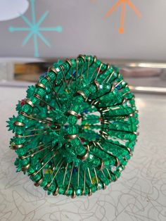 a green brooch sitting on top of a table