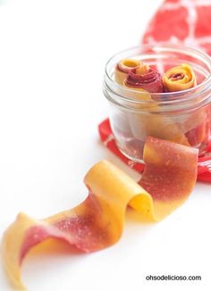 a jar filled with candy sitting on top of a white table next to other candies