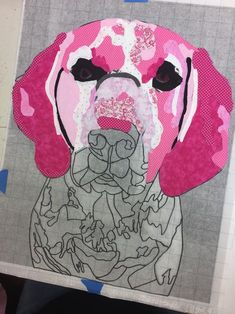 a pink dog with black eyes is shown on a piece of paper that has been cut out