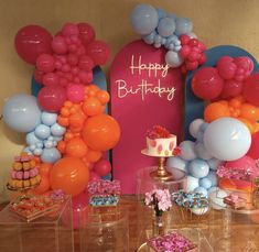 a birthday party with balloons, cake and cupcakes