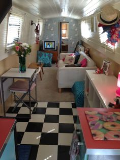 a living room filled with lots of furniture and decor on top of checkered flooring