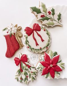 decorated christmas cookies on a plate with holly decorations