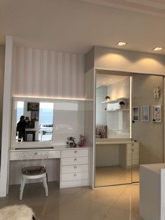 a bedroom with a vanity, desk and mirror in it's center wall is lit by recessed lights