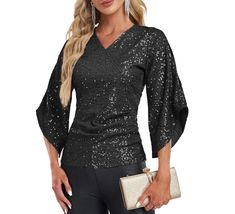 a woman wearing a black top with sequins on the shoulders and bell sleeves