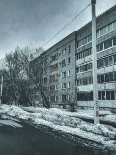 an old brick building with snow on the ground