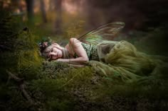 a fairy laying on the ground with her eyes closed