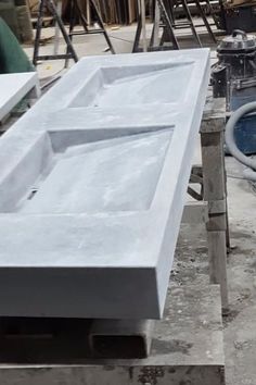 two sinks sitting on top of a table in the middle of a construction area with tools nearby