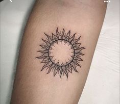 a black and white photo of a sunflower tattoo on the right arm, with an outline in the middle