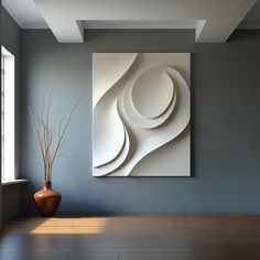 an abstract painting hangs on the wall next to a vase with a plant in it