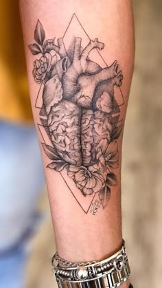 a woman's arm with a heart tattoo on it and flowers in the middle