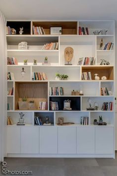 a white book shelf filled with lots of books on top of it's shelves