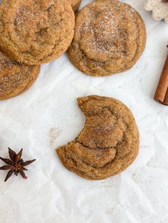 cinnamon sugar cookies and anisette on white parchment paper with cinnamon sticks, star anisette and spices