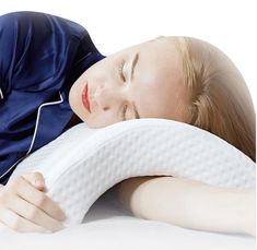 a woman laying on top of a pillow with her head resting on the pillow that she is holding