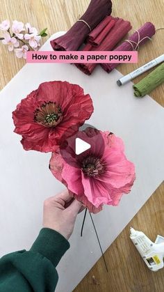 someone is making paper poppys on the table