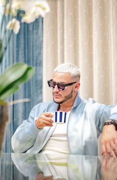 a man sitting on a couch wearing sunglasses