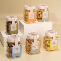 six jars filled with different types of candies sitting on top of a white box