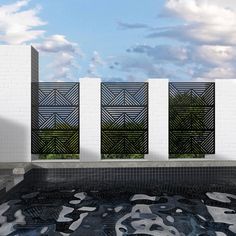 an empty swimming pool in front of three white walls with black and grey designs on them