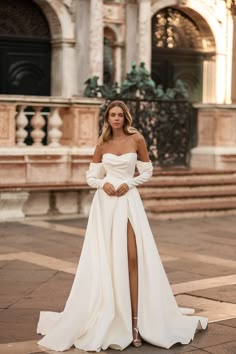 a woman in a white wedding dress posing for the camera