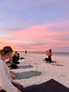 people are doing yoga on the beach at sunset